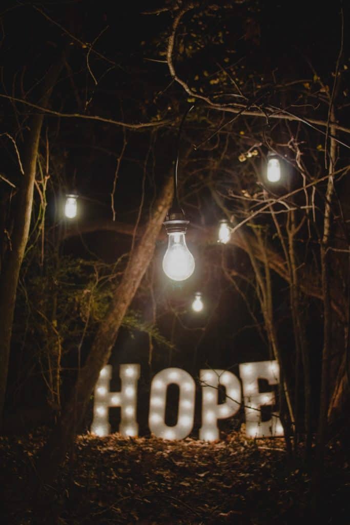 Hope spelled in lights in the forest at night.